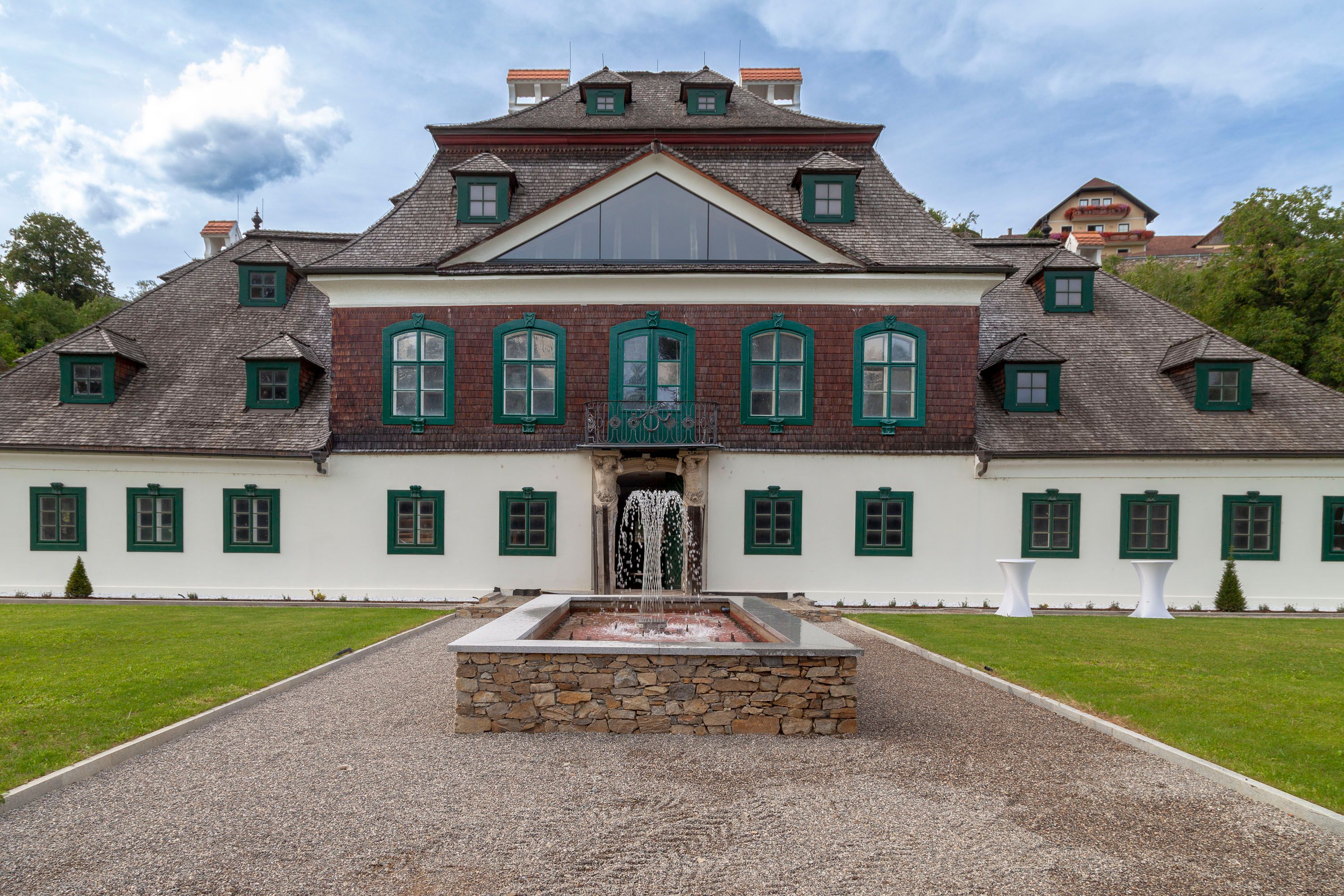 Exterior view of Schloss Luberegg with fountain in the foreground.