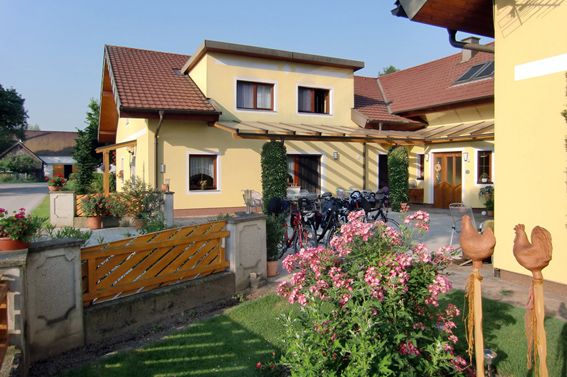 Yellow house with garden and bicycles in front of the door.