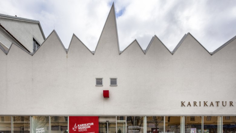 Facade of the Caricature Museum Krems with jagged roof and red square.