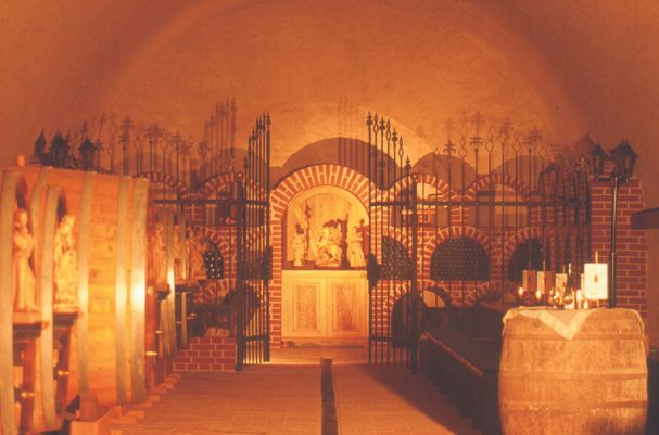 A wine cellar with wooden barrels and decorative grilles.