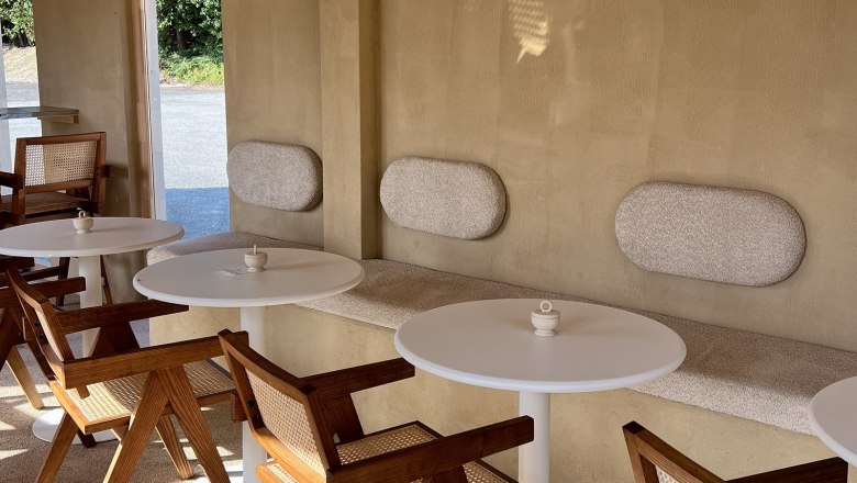 Interior of a café with wooden furniture and round tables.