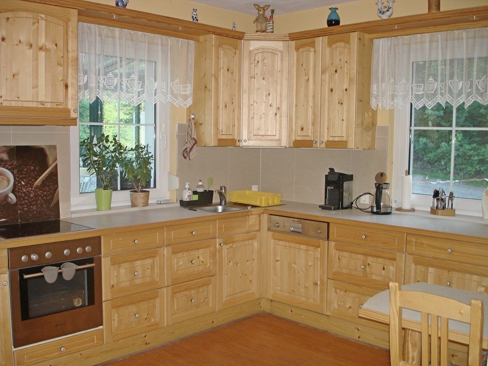 Wooden kitchen with appliances and plants in a vacation home.