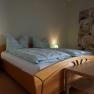 Bedroom with double bed, bedside tables and table.