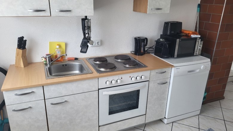 Kitchenette with stove, sink, microwave and dishwasher.