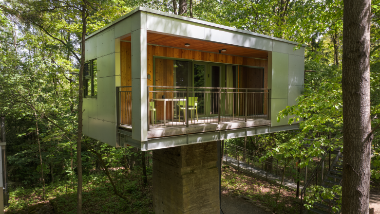 House on the foundation, © edelforst Baumhäuser © Robert Tober Modern tree house in the forest with balcony and glass front.