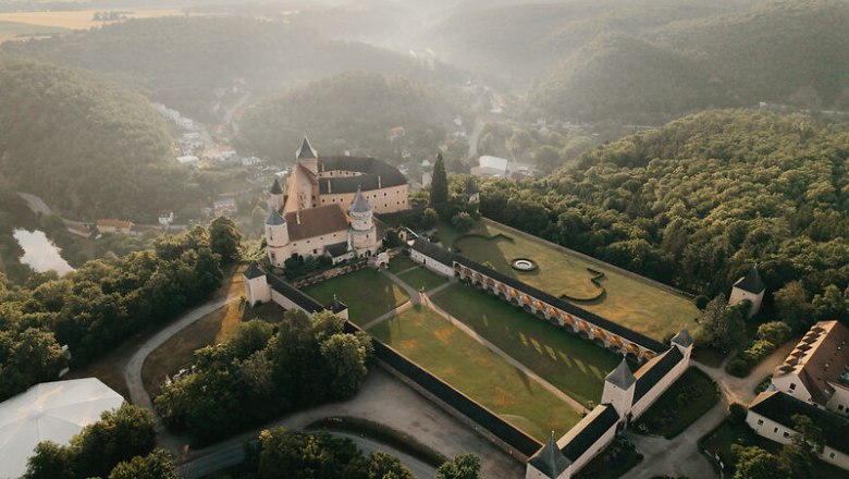 Aerial view of the Rosenburg surrounded by green forests and hills.