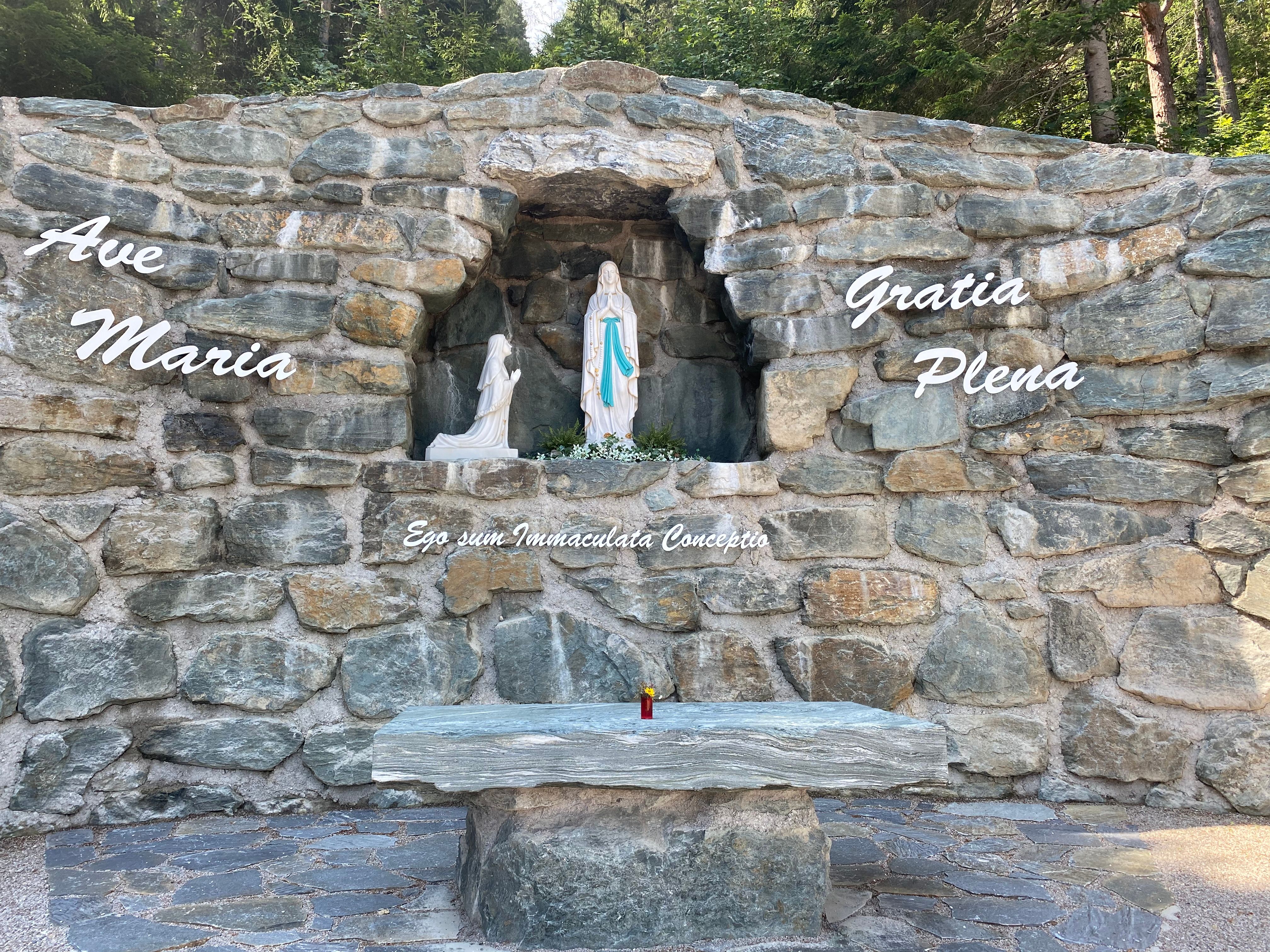 Stone grotto with statue of the Virgin Mary and inscription 'Ave Maria'.