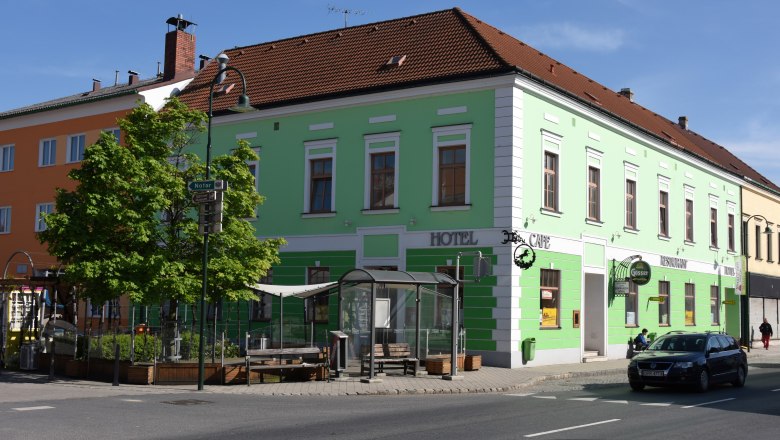 Wine Hotel Rieder, © Familie Rieder Green building with hotel and café signs on a street corner.