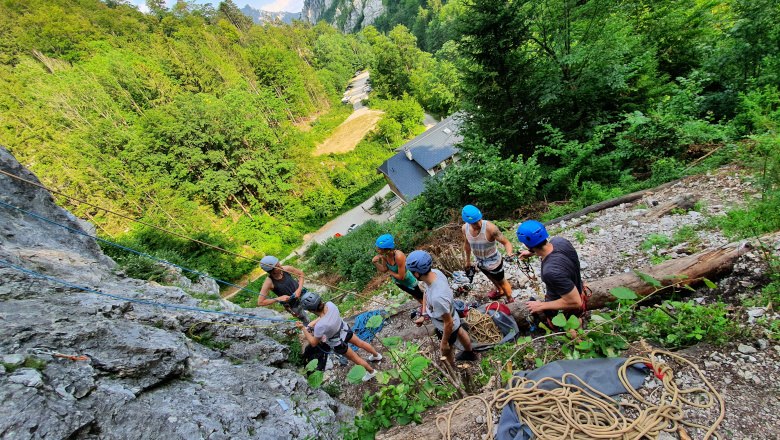 Group of climbers with helmets on a rock in the forest.