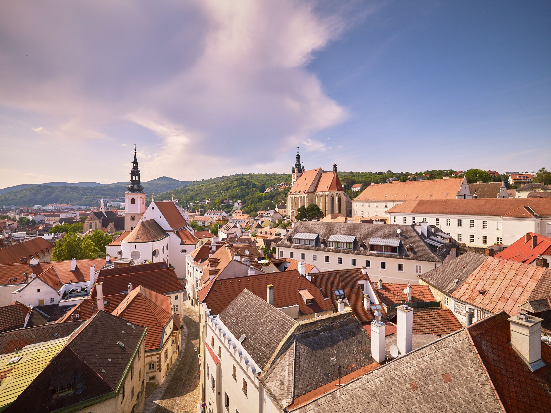 Panoramic view of the old town of Krems with churches and red roofs.
