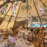 Interior view of a festively decorated tipi with round tables and flowers.