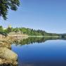 Kampsee Ottenstein with calm water, wooded shores and a castle in the background.