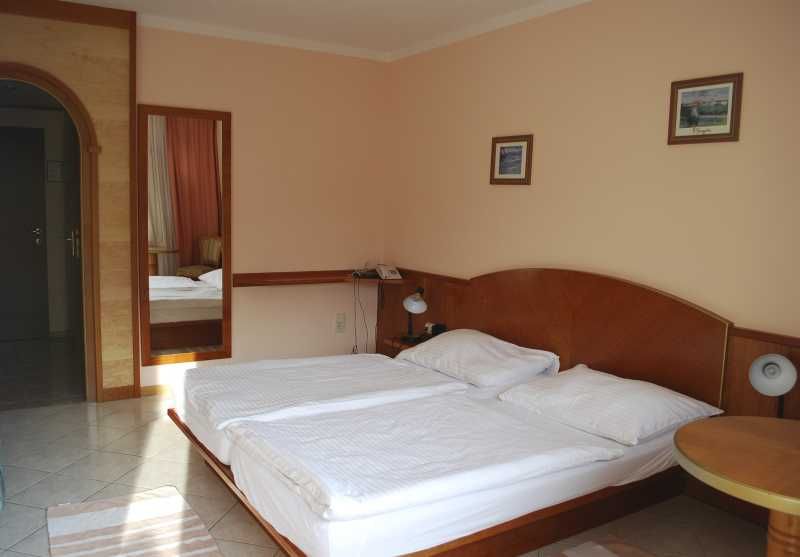 Hotel room with double bed, bedside lamps and murals.