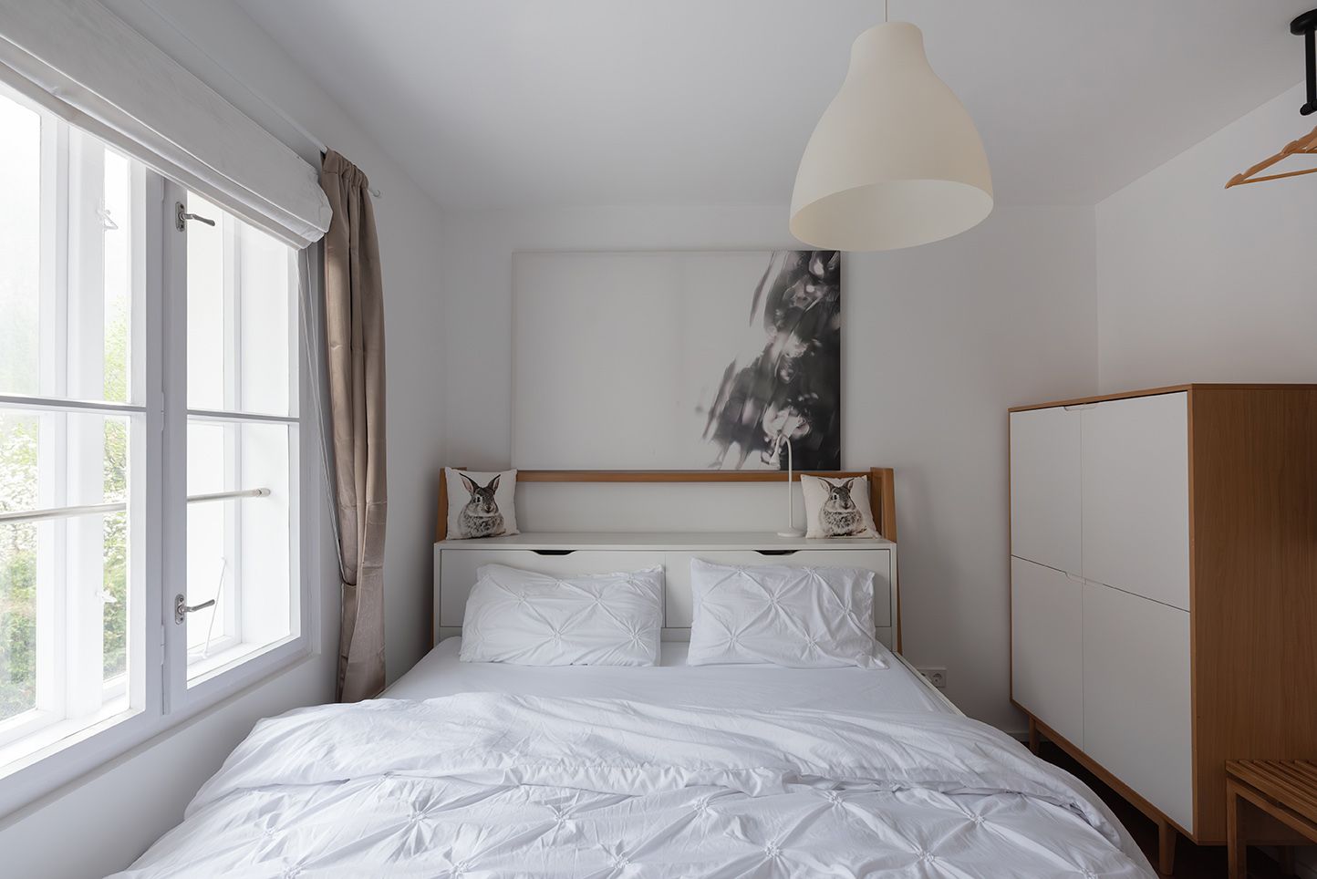 Modern bedroom with white bed and minimalist decoration.