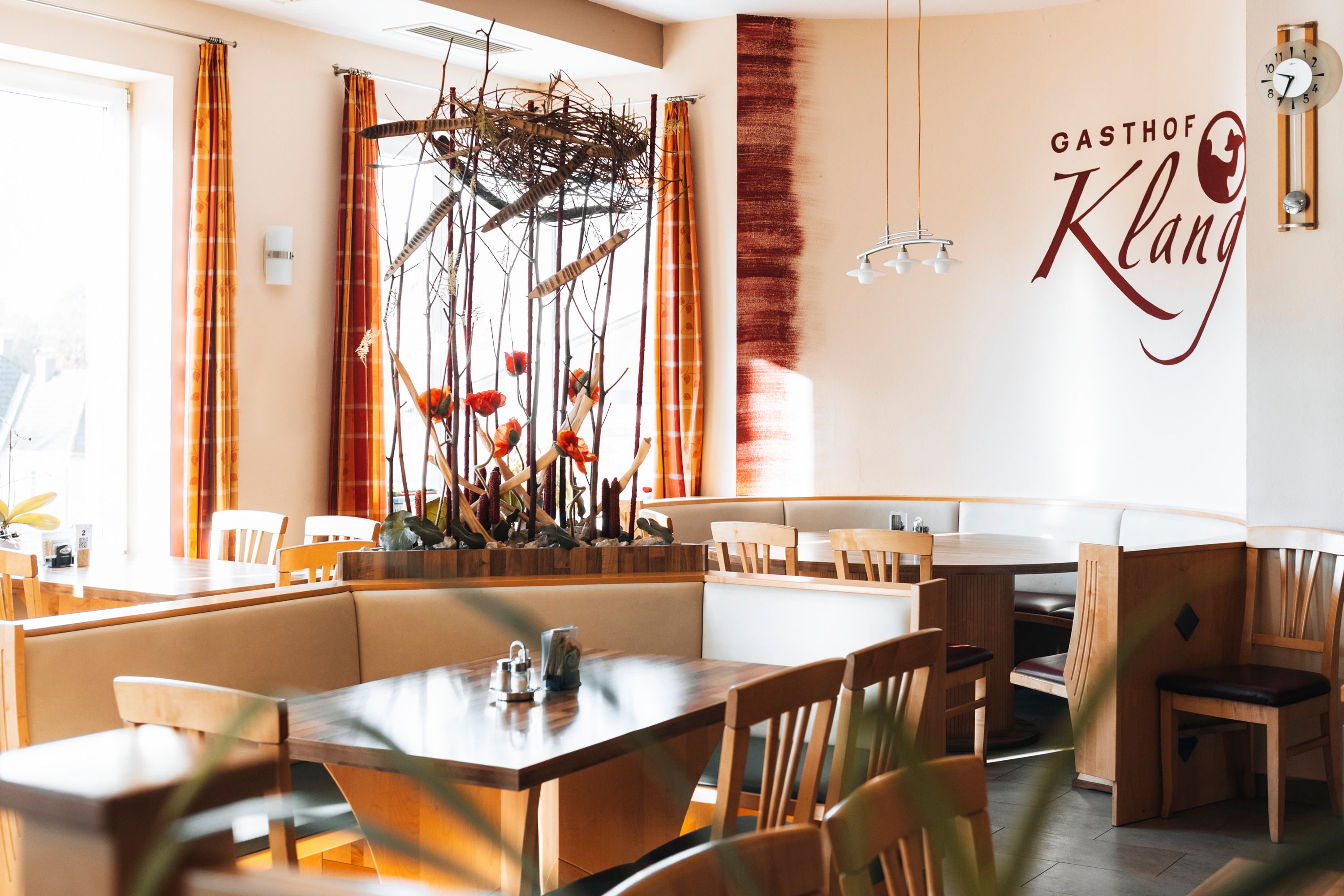 Interior view of a restaurant with wooden furniture and decorative plants.