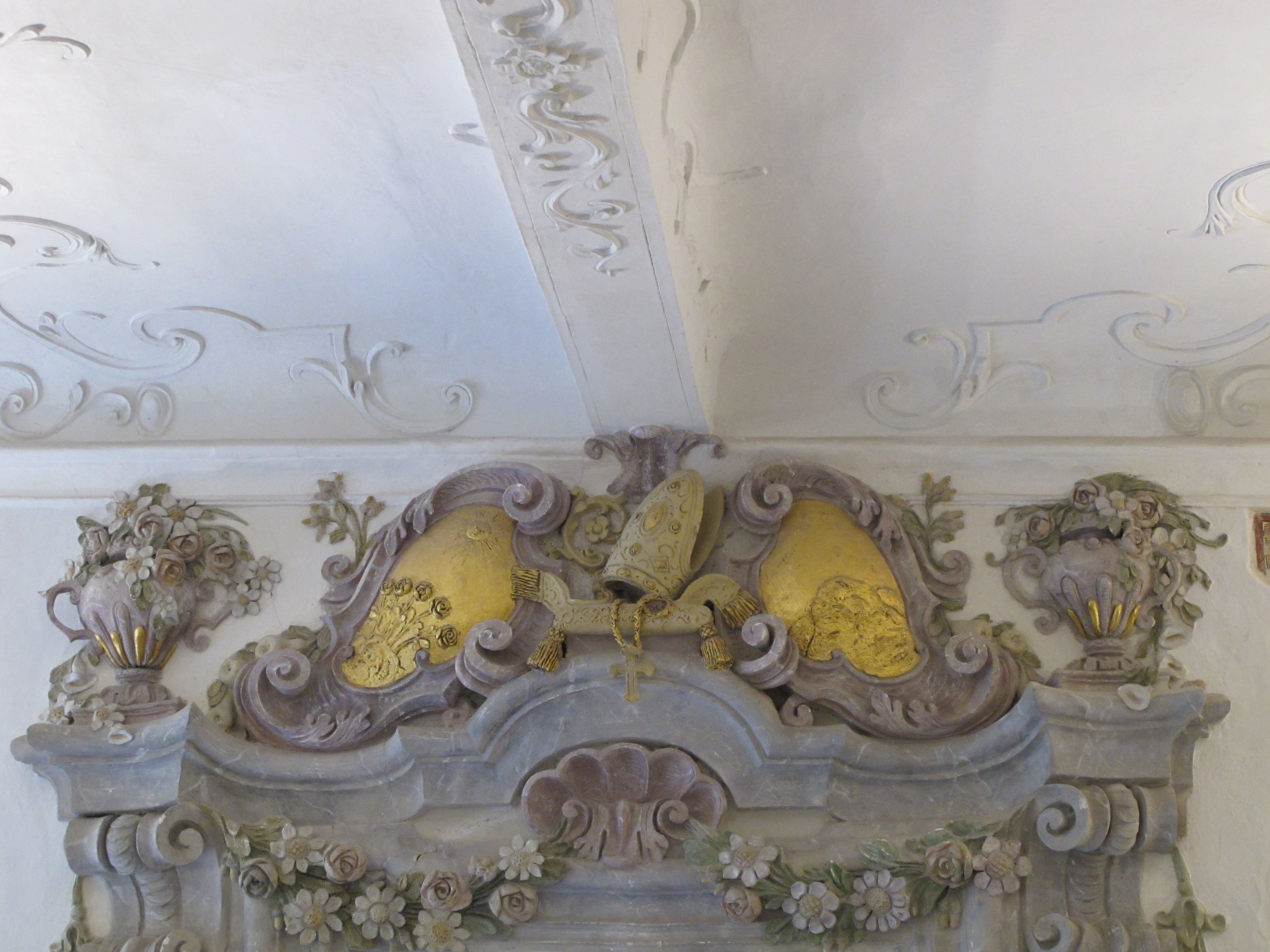 Baroque stucco decoration with floral motifs and golden elements on one ceiling.