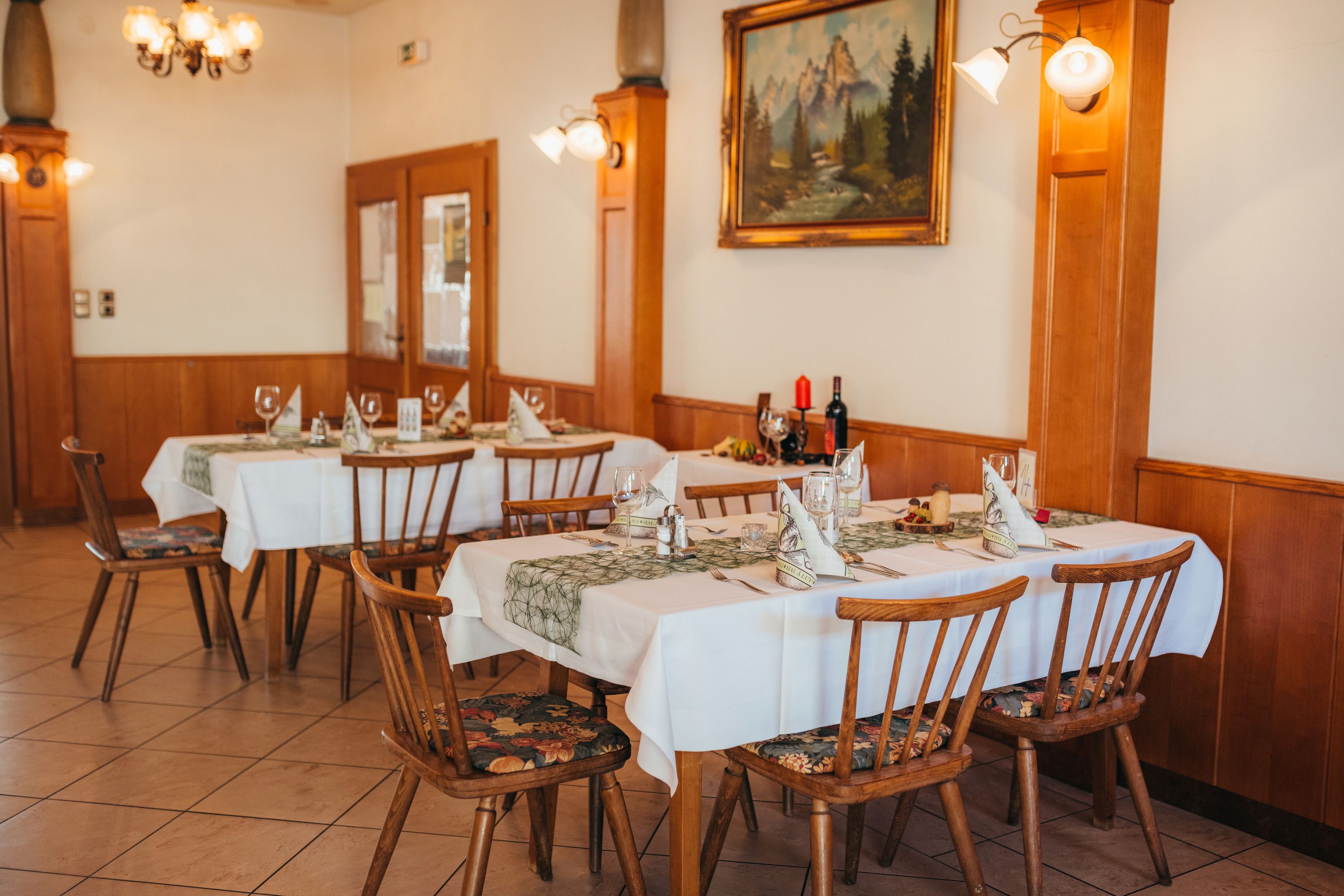 Cozy restaurant with laid tables and rustic furnishings.