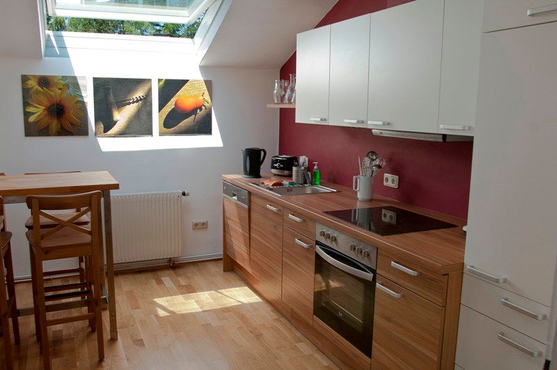 Modern kitchen with wooden worktop, skylight and murals.