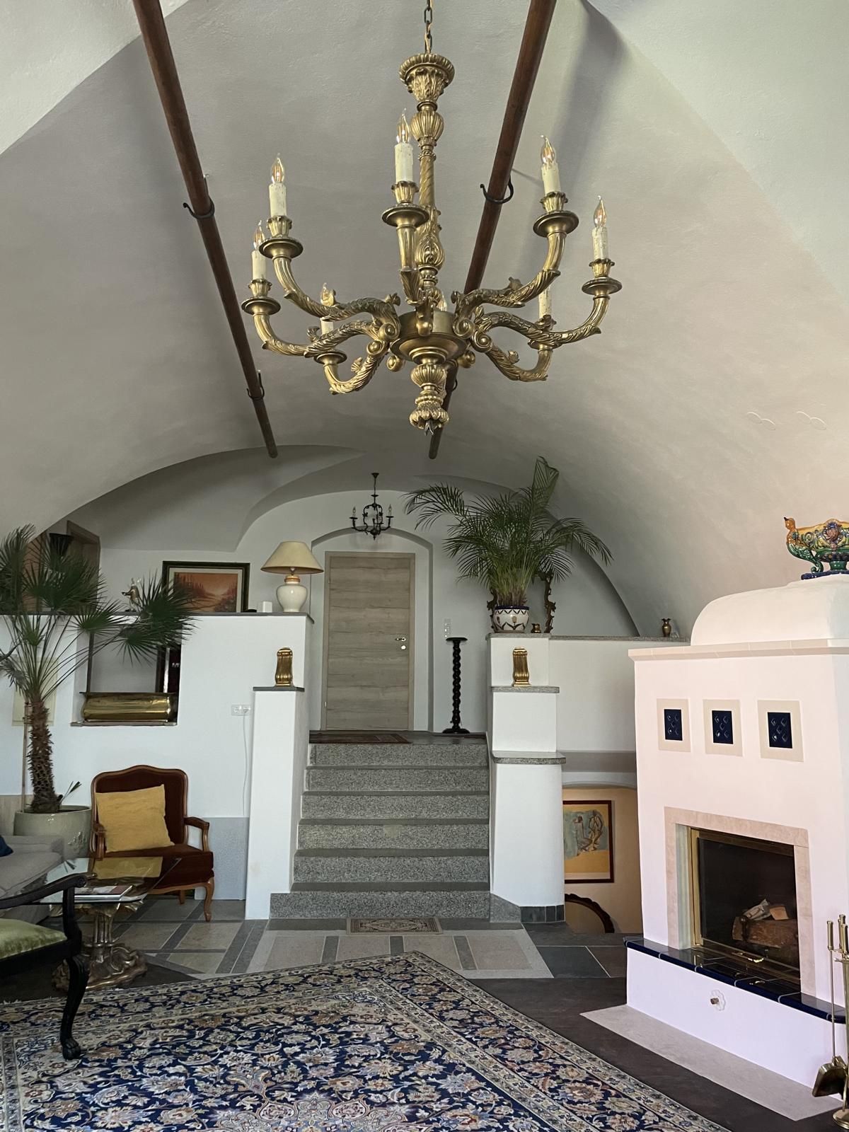 Elegant room with chandelier, fireplace and staircase.