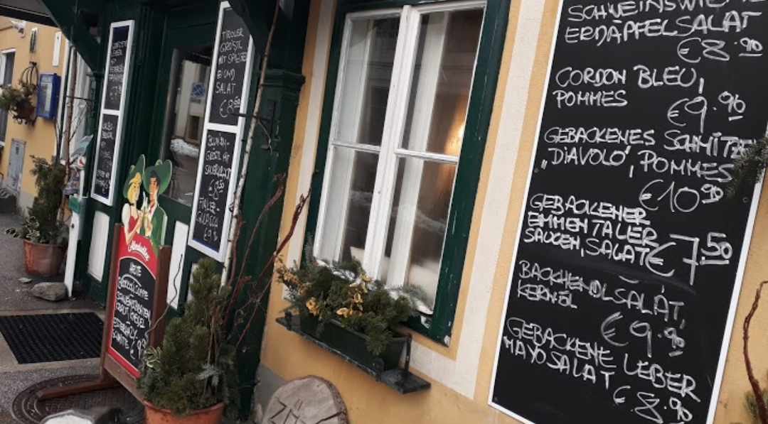 Entrance to a pub with several boards showing food and prices.