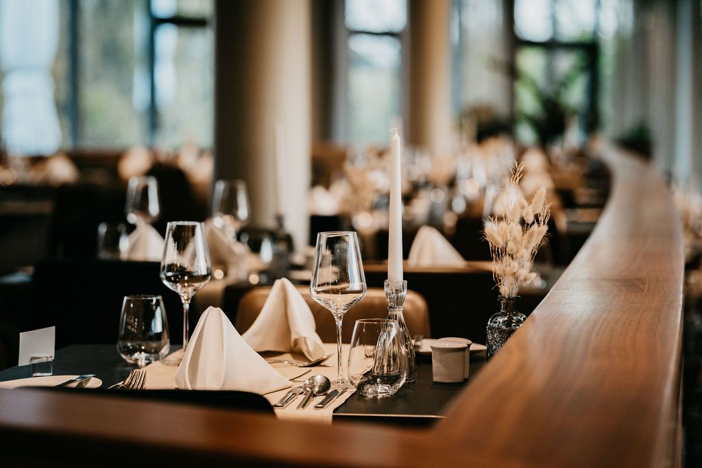 Elegant restaurant with laid table, wine glasses and candles.