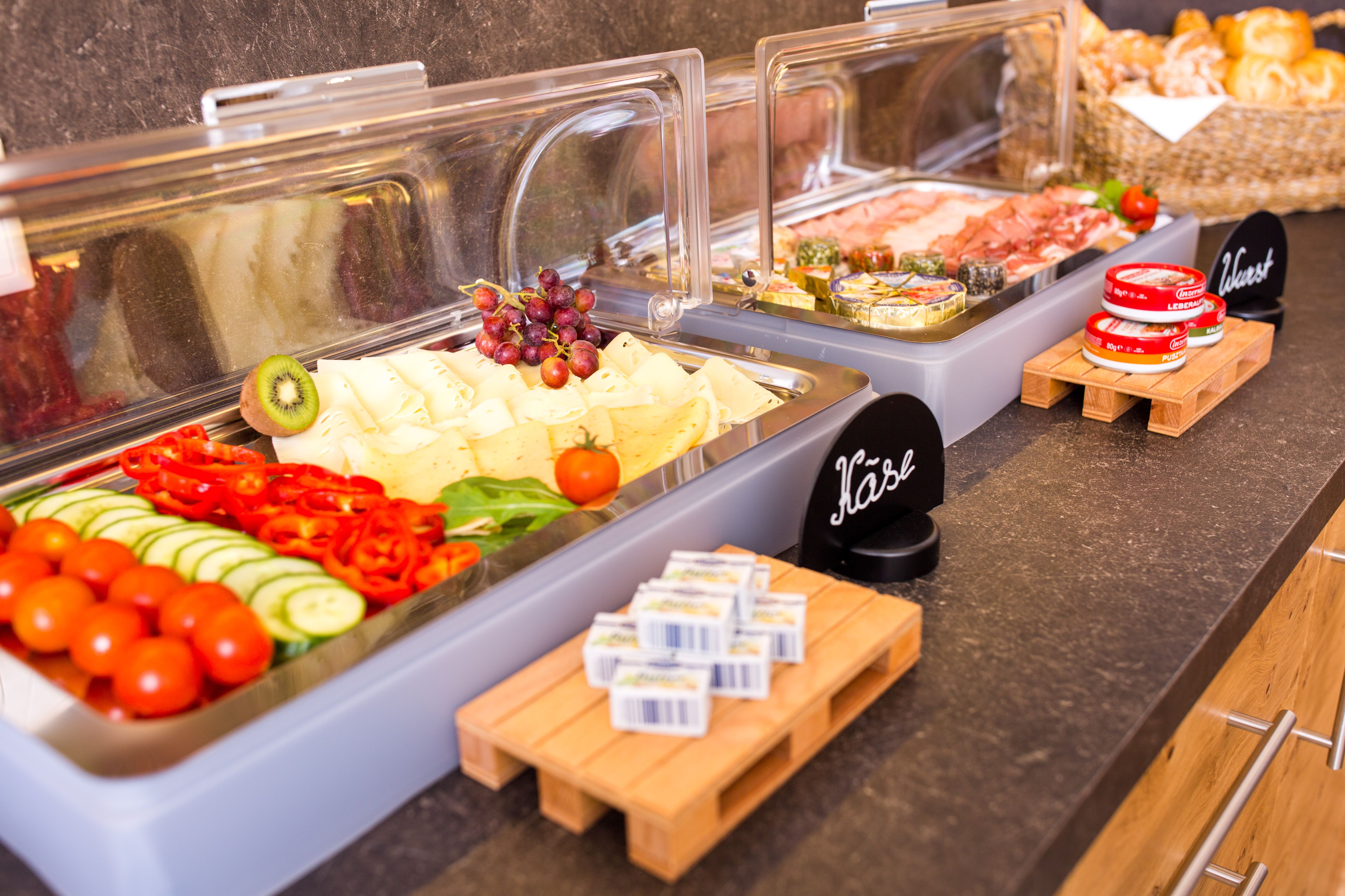 Buffet with cheese, cold cuts, vegetables and bread.