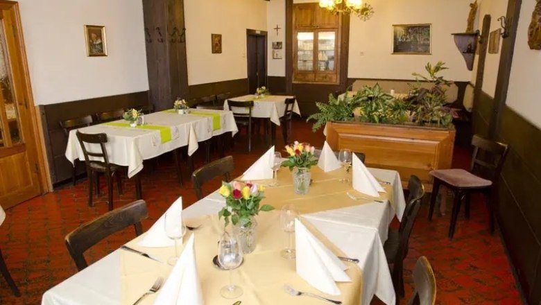 Interior view of a traditional restaurant with laid tables and plants.