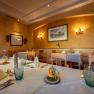 Elegant restaurant with laid tables, white tablecloths and decorative glasses.
