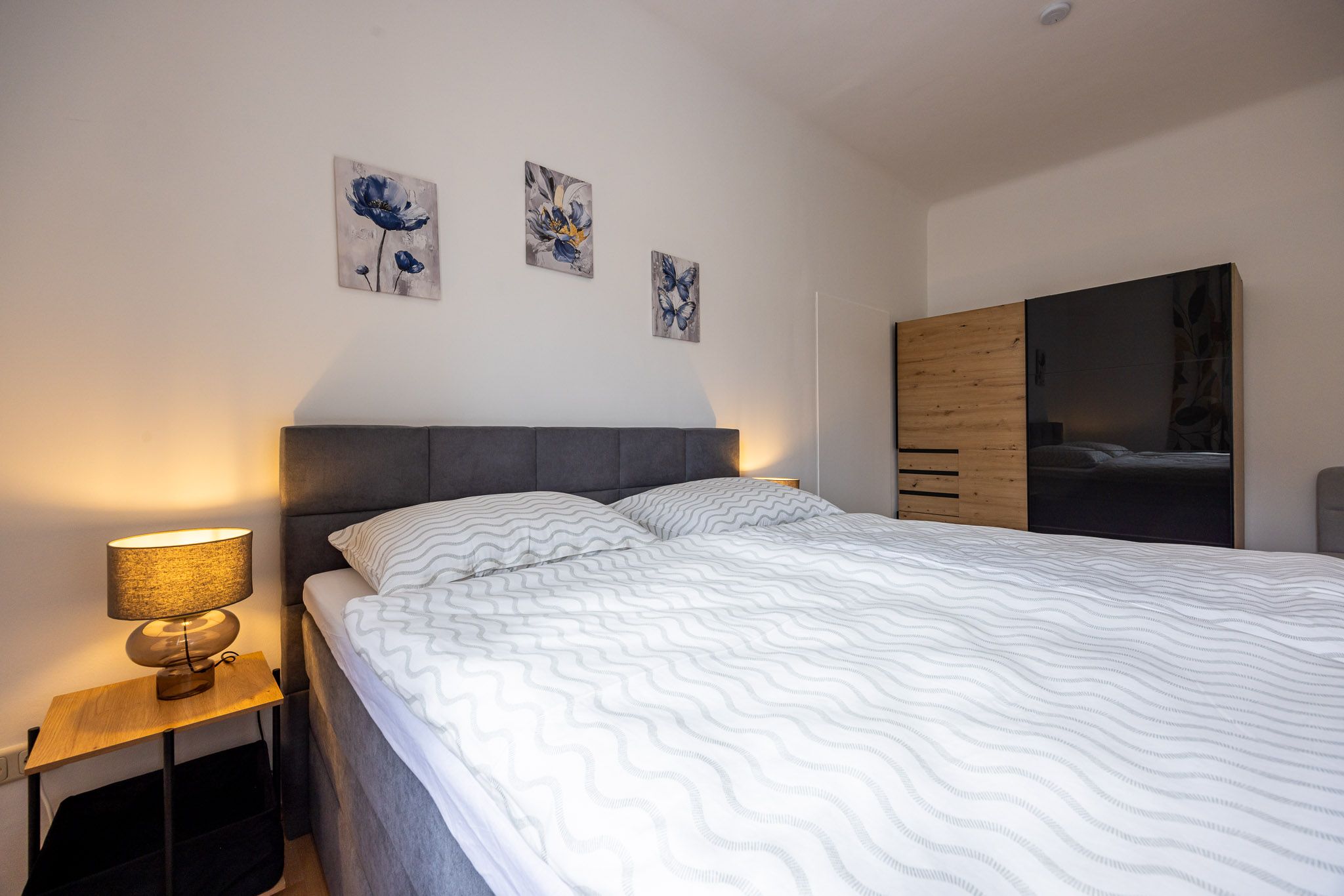 Bedroom with large bed, bedside table and wardrobe.
