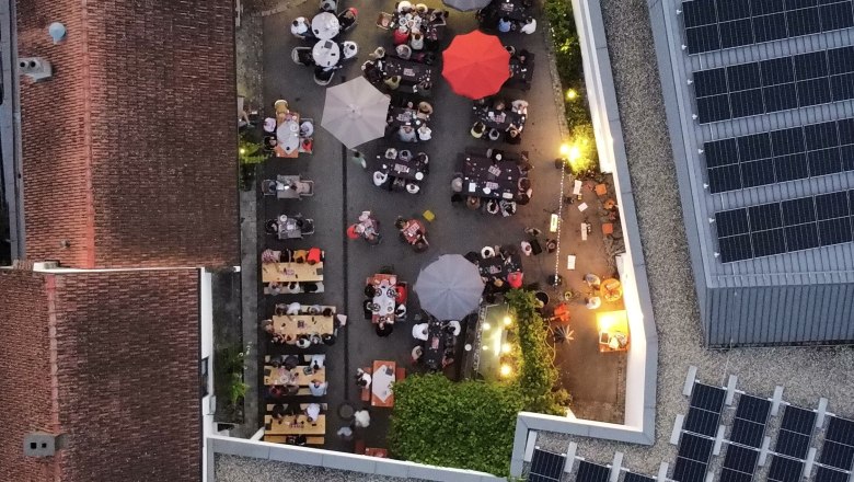Aerial view of a winery with tables and parasols in the courtyard.