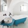 Modern bathroom with blue bathtub and washbasin.