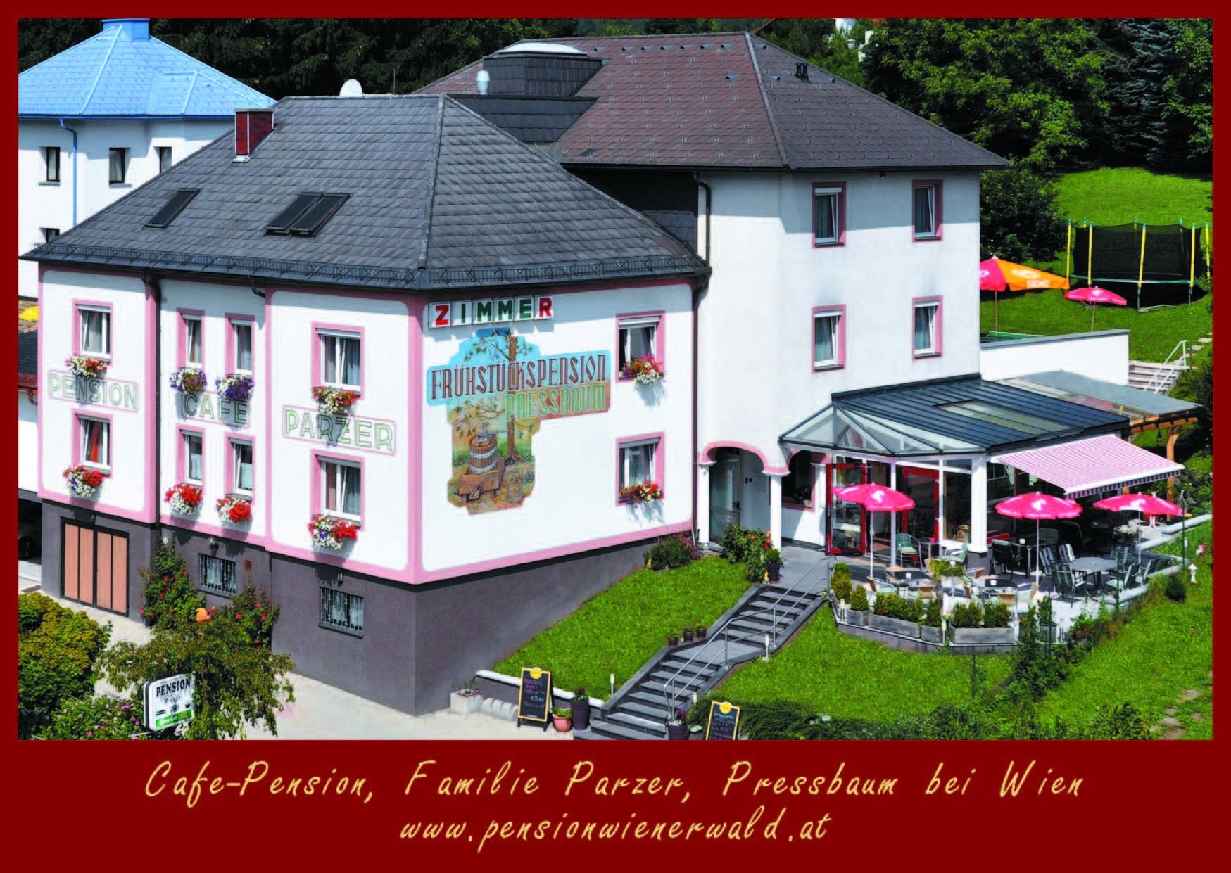 Exterior view of Cafe-Pension Parzer with terrace and parasols.