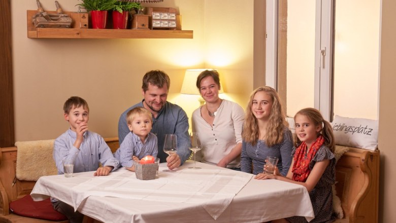 Family sitting at a table in a cozy room.