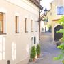 Narrow alley in the Wachau with yellow houses and a lantern.