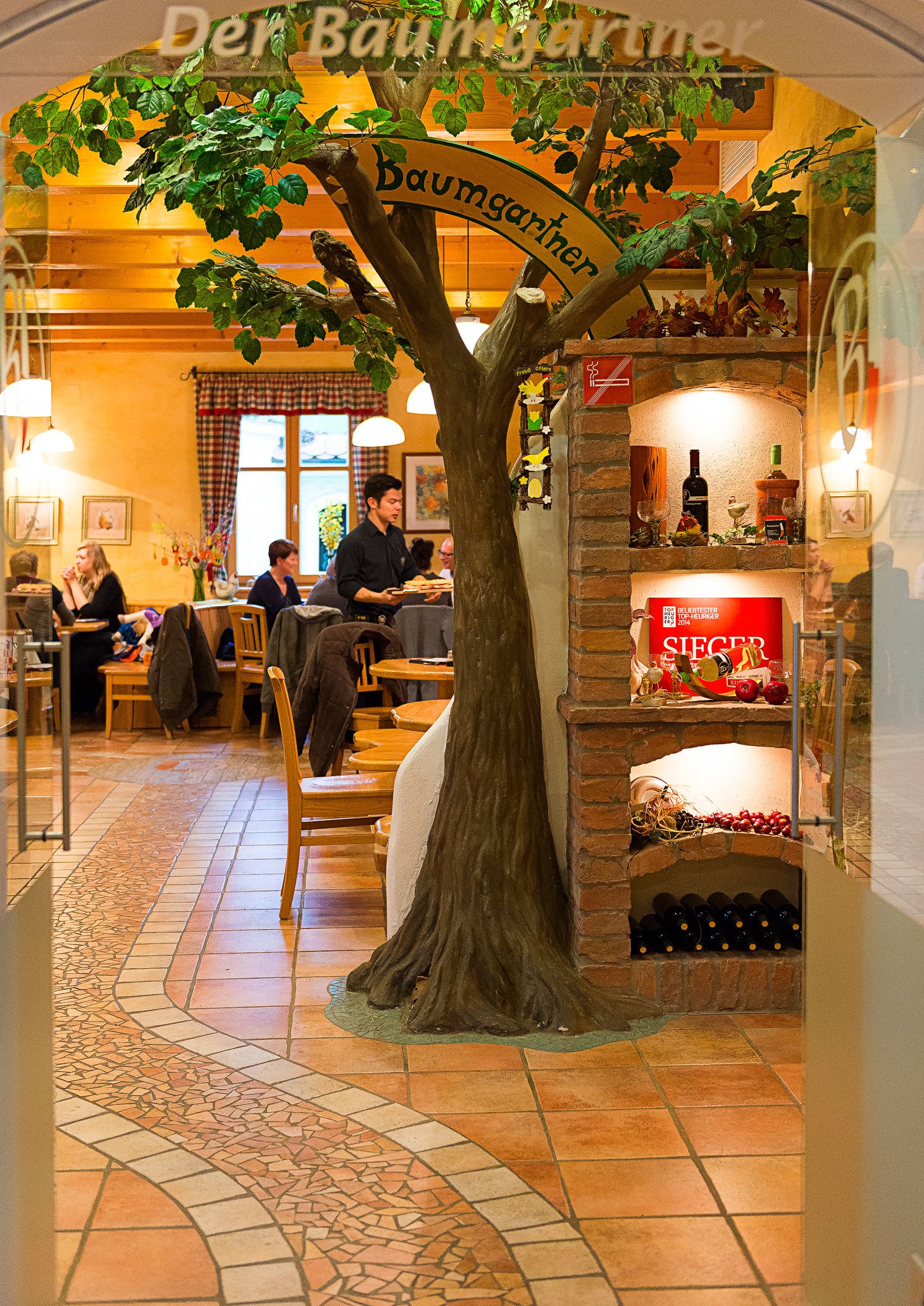 Interior view of a wine tavern with tree decoration and wine rack.
