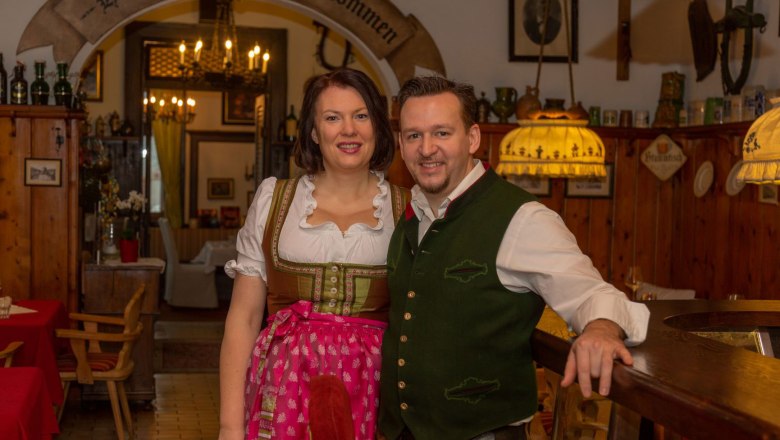 A couple in traditional Bavarian costume in a rustic inn.
