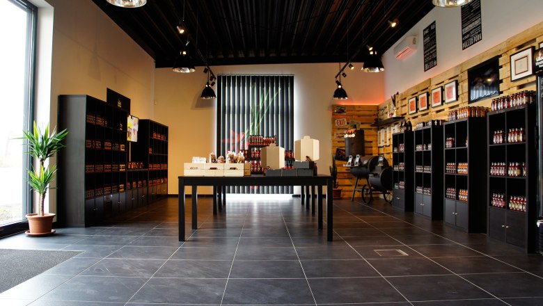 Interior view of a modern store with shelves full of products and a table in the middle.