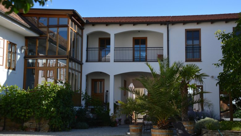 Inner courtyard of a winery with plants and seating area.