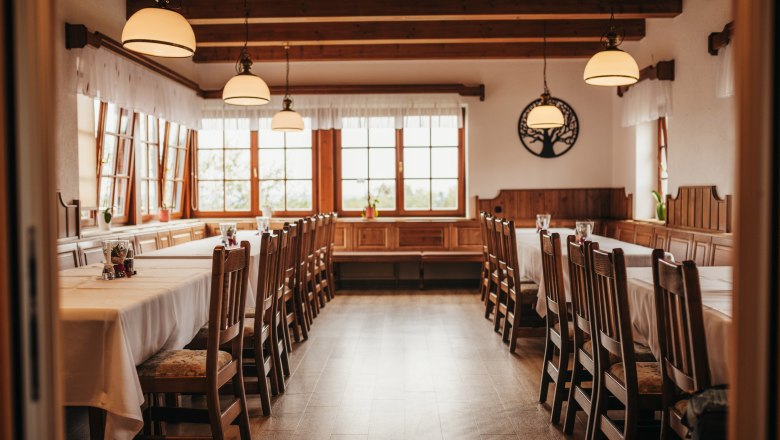 Cozy dining room with wooden furniture and large windows.