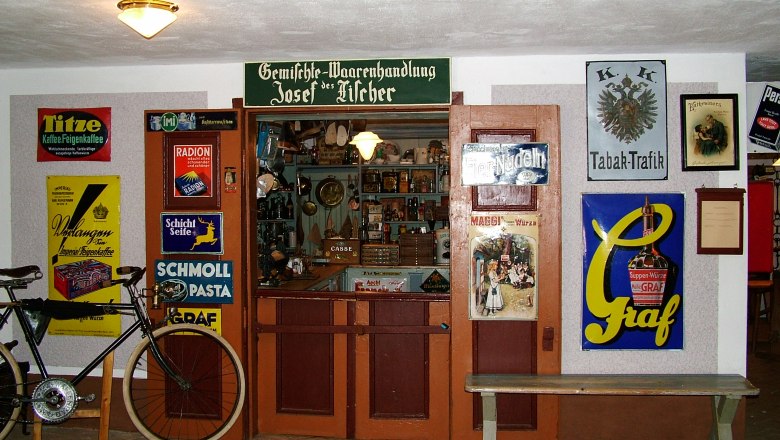 Historic store in the Mostviertel Farmers' Museum with old advertising signs and a bicycle.