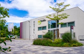 Exterior view of the College Garden Hotel with modern architecture and garden.
