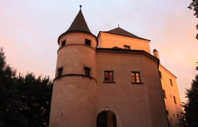 Wildegg Castle at sunset with illuminated towers and windows.