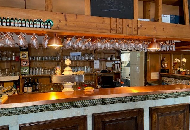 Interior view of a rustic bar with wooden decor and glasses.