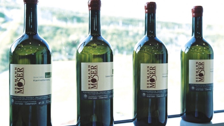 Four bottles of wine from the Hermann Moser winery on a windowsill.