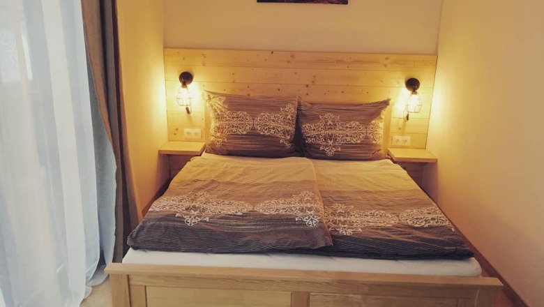 Cozy double room with wooden bed and bedside lamps.