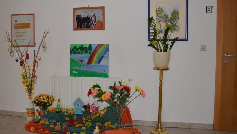Decorated entrance area with pictures, plants and Easter decorations.