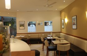 Interior view of a café with tables, chairs and wall decorations.