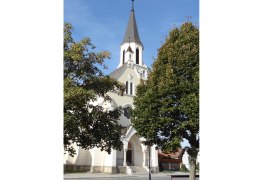 Church in Dobermannsdorf with trees in the foreground.
