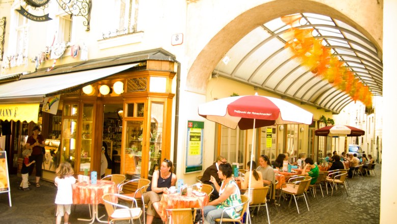 Outdoor area of the patisserie with tables and parasols in the pedestrian zone of Krems.