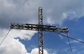 A large summit cross on a mountain peak